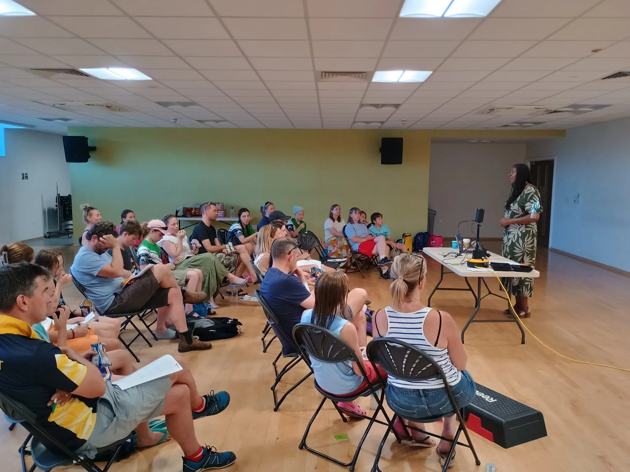 Lorraine Lee speaking to a room of young athletes and parents seated in a circle