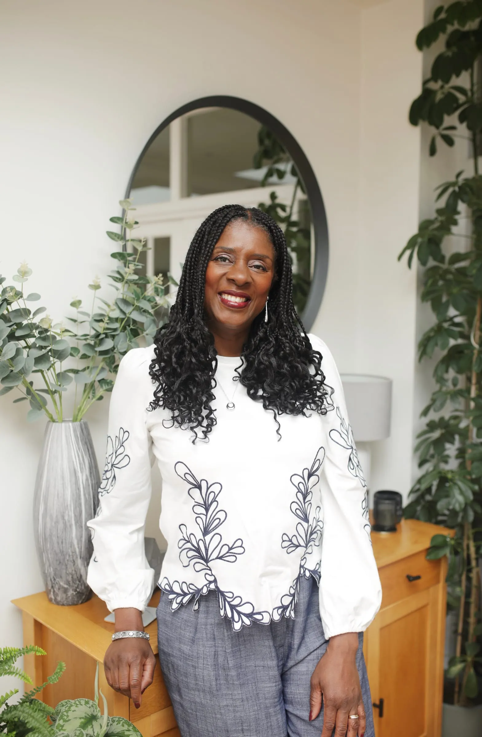 Lorraine Lee standing in a bright room, smiling