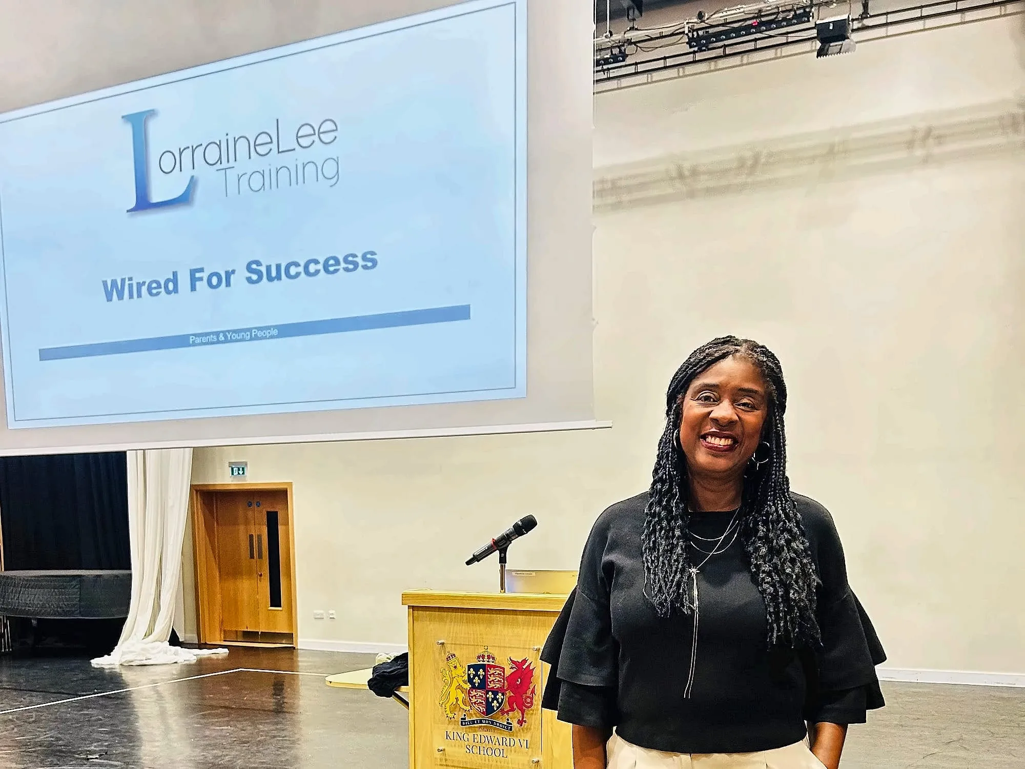 Lorraine Lee at a lectern beside a slide reading Wired For Success