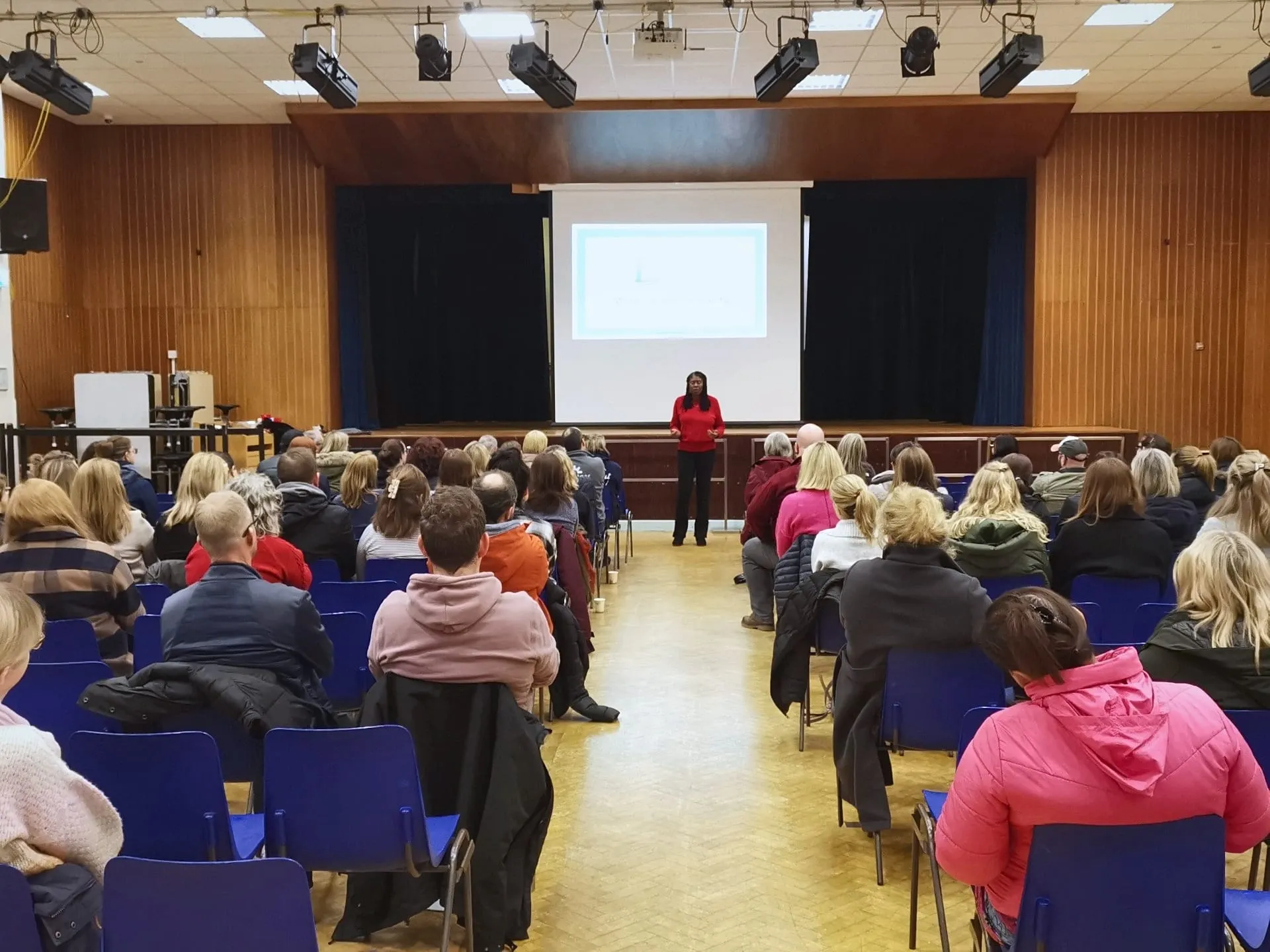 Lorraine speaking to a hall full of parents at a secondary school