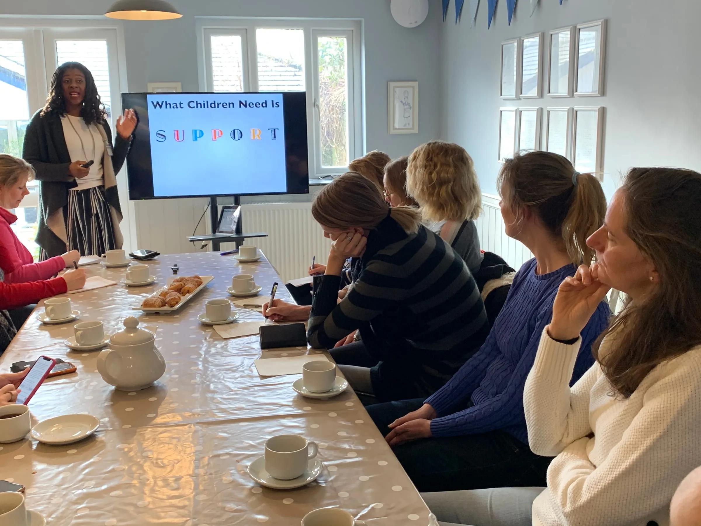 Lorraine Lee leading a workshop for a group of parents around a table at home