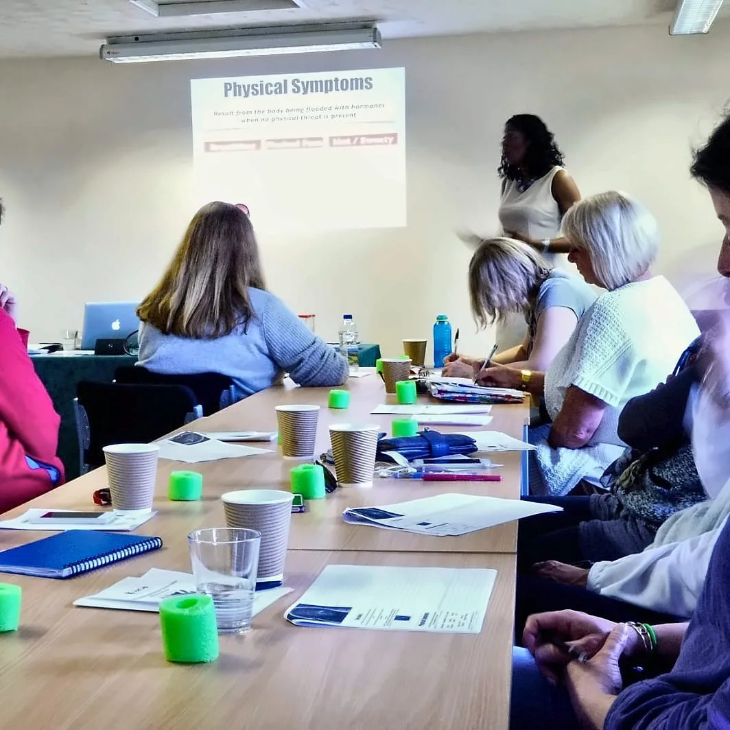 Lorraine leading a workshop for a room of working parents around a table